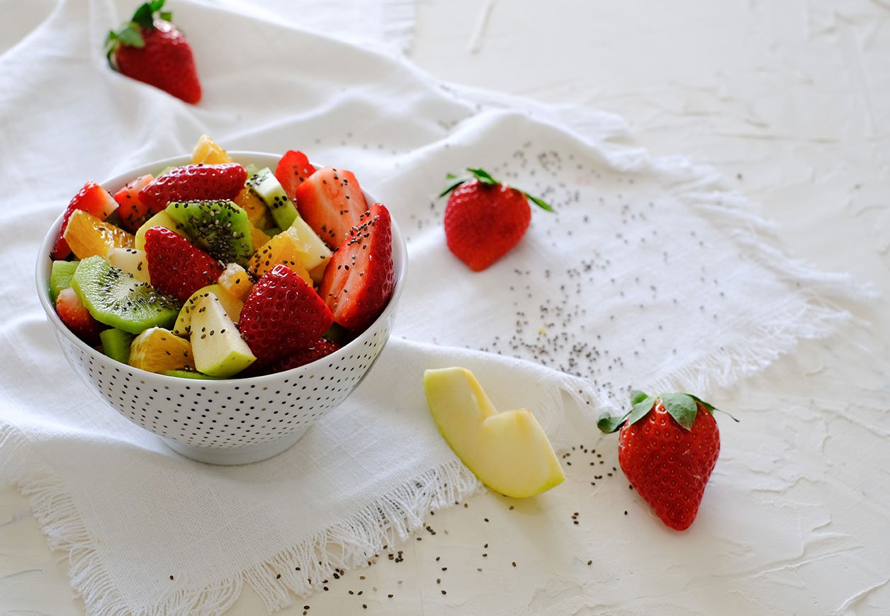 Bowl Of Healthy Fresh Fruit Salad And Chia Seeds On White Napkin
