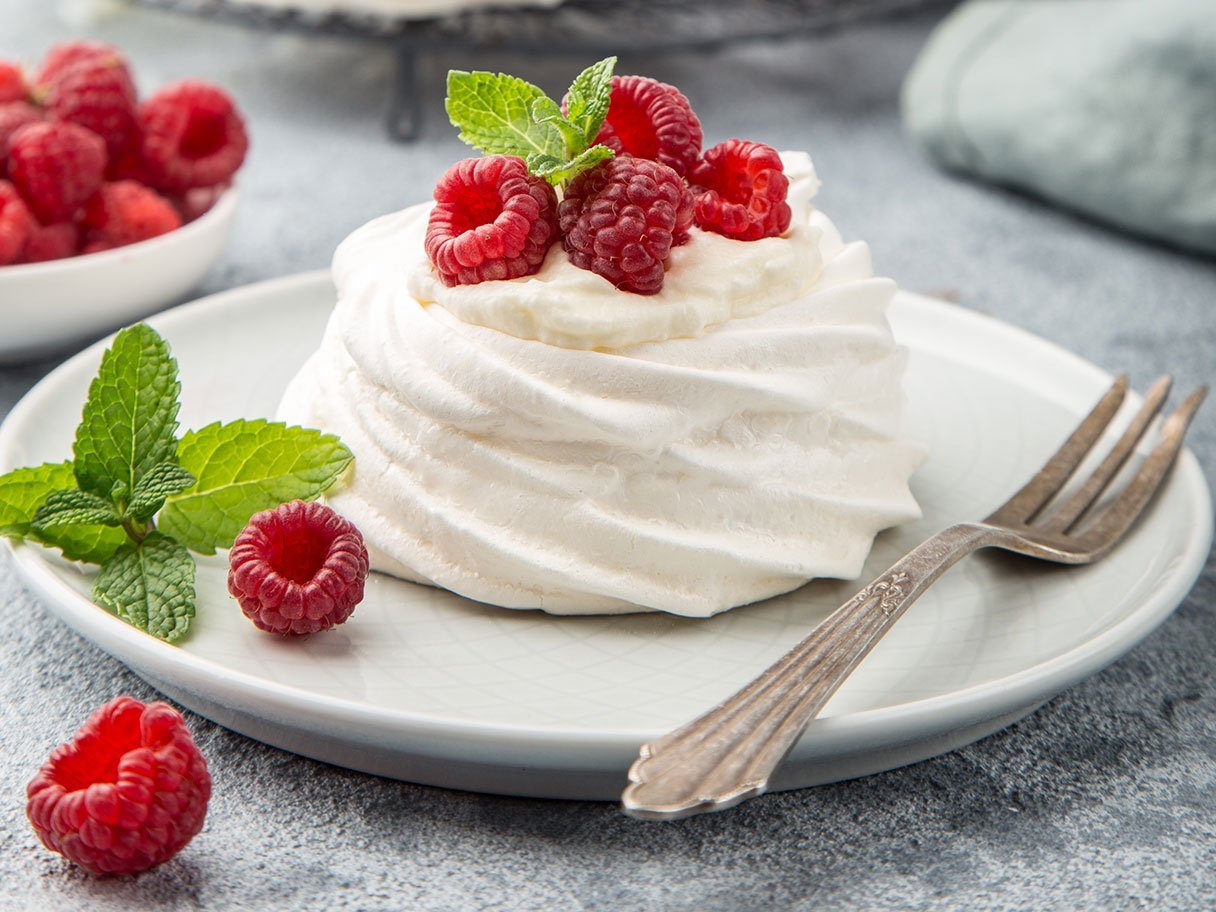 Mini Pavlova Meringue Cakes With Whipped Cream And Fresh Raspbe