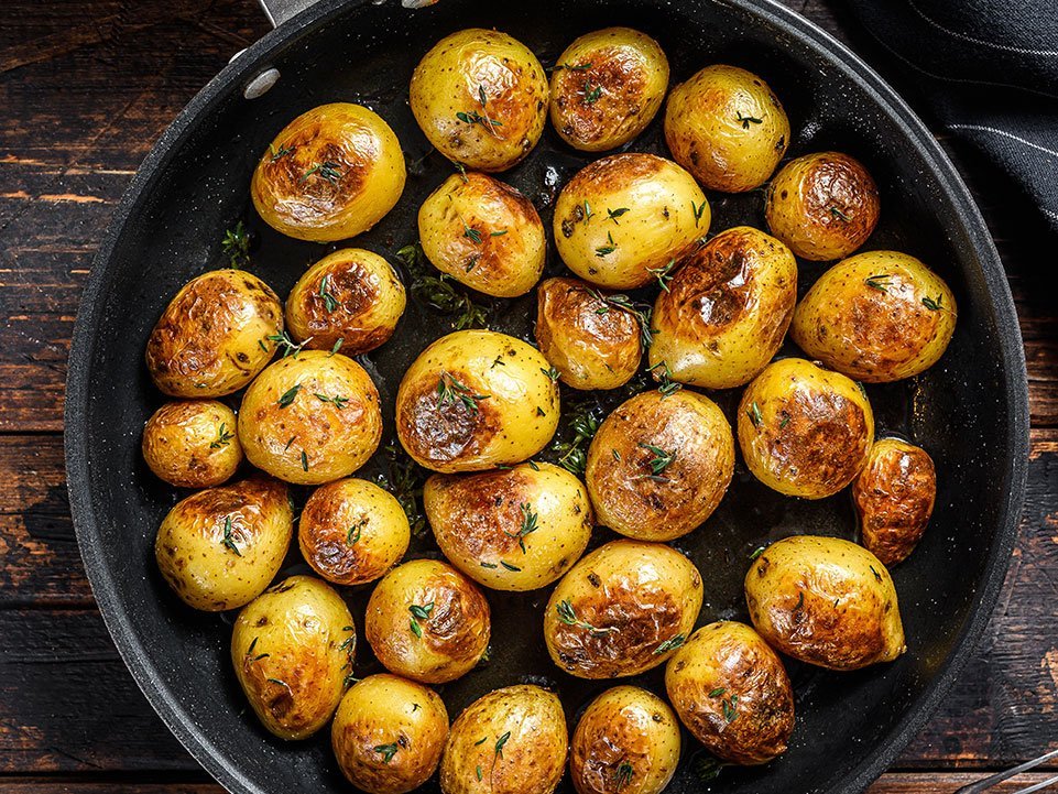 Baked Baby Potatoes In A Cast Iron Skillet. Dark Wooden Backgrou