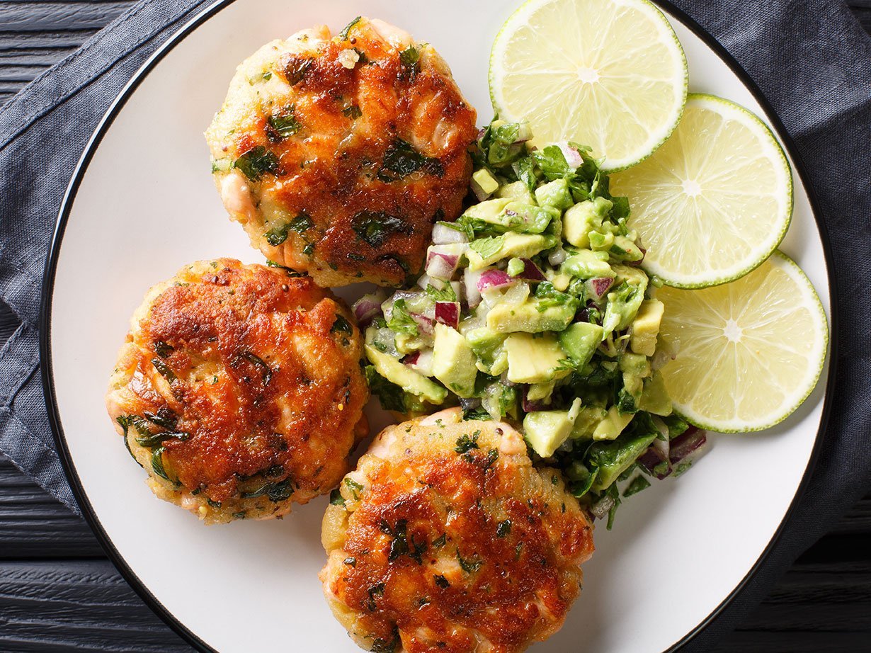 Freshly Made Salmon Burgers With Avocado Salsa And Lime Close Up