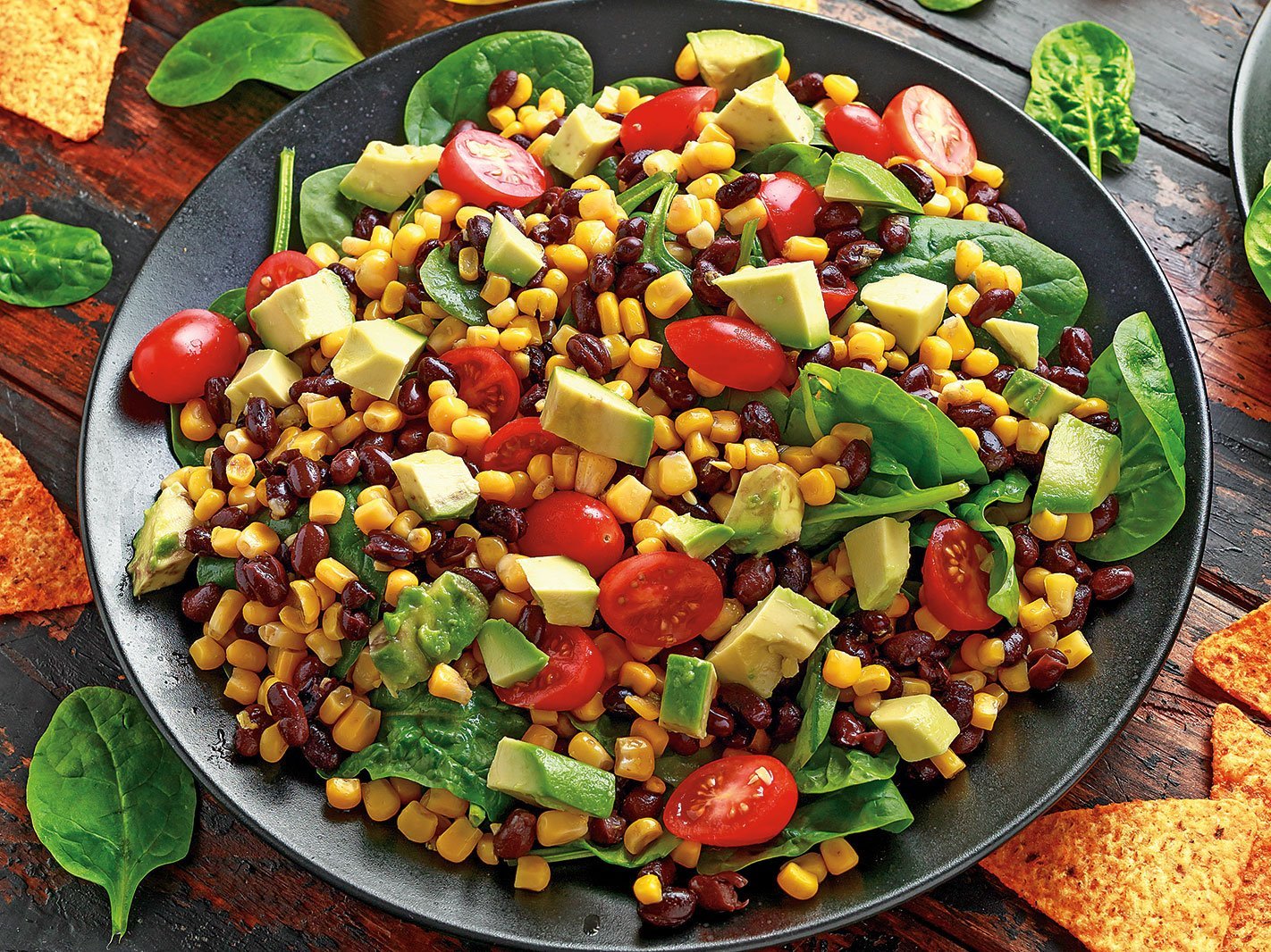 Mexican Salad With Avocado, Black Beans, Sweet Corn, Spinach, Tomatoes And Tortilla Chips