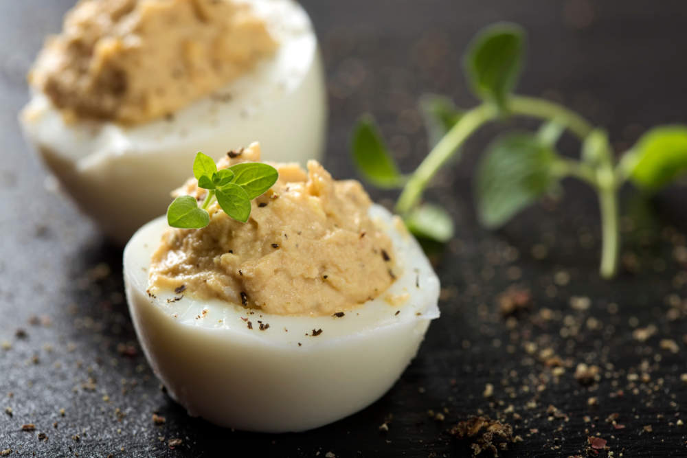 Close Up Of Stuffed Eggs With Herbs On A Dark Slate