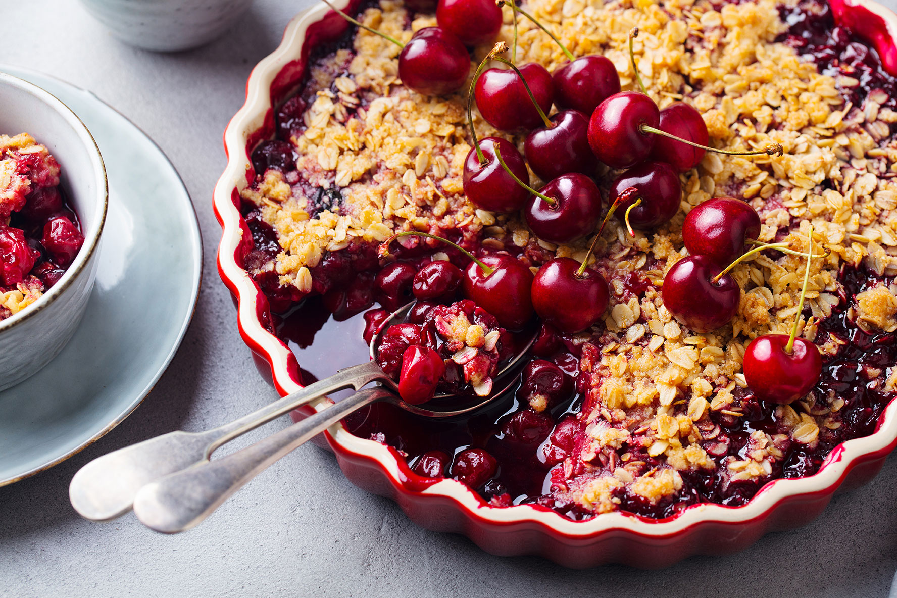 Cherry, Red Berry Crumble In Baking Dish. Grey Stone Background. Close Up.