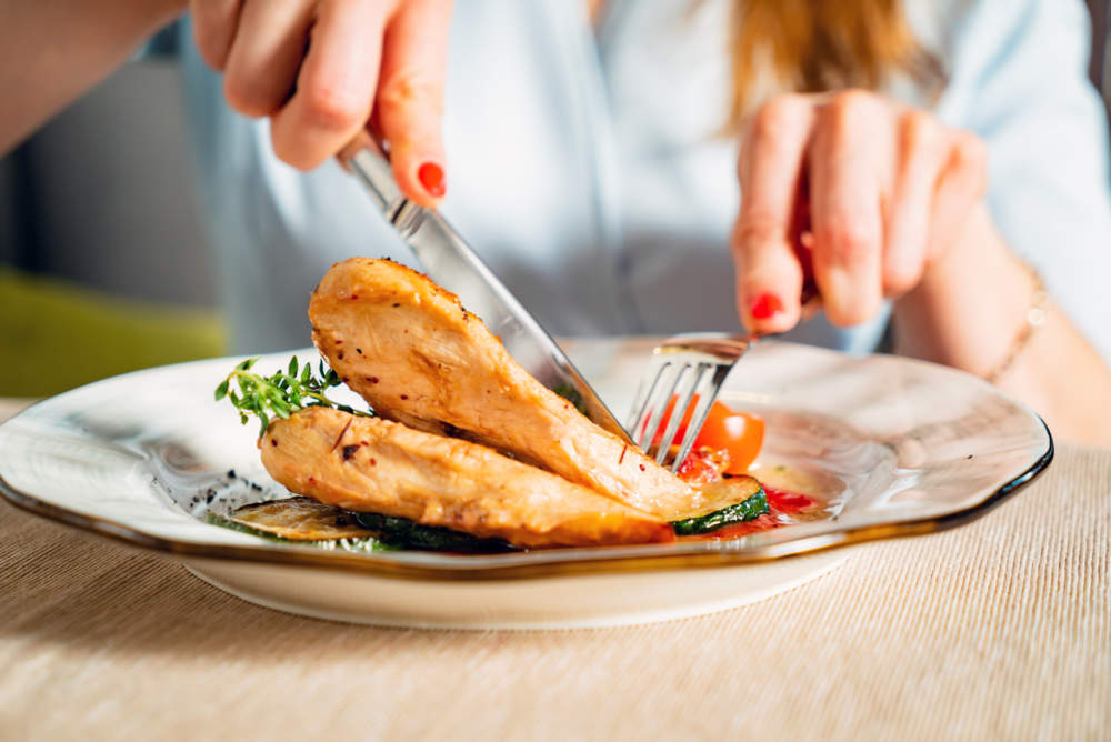 Woman Eating Grilled Chicken Breast