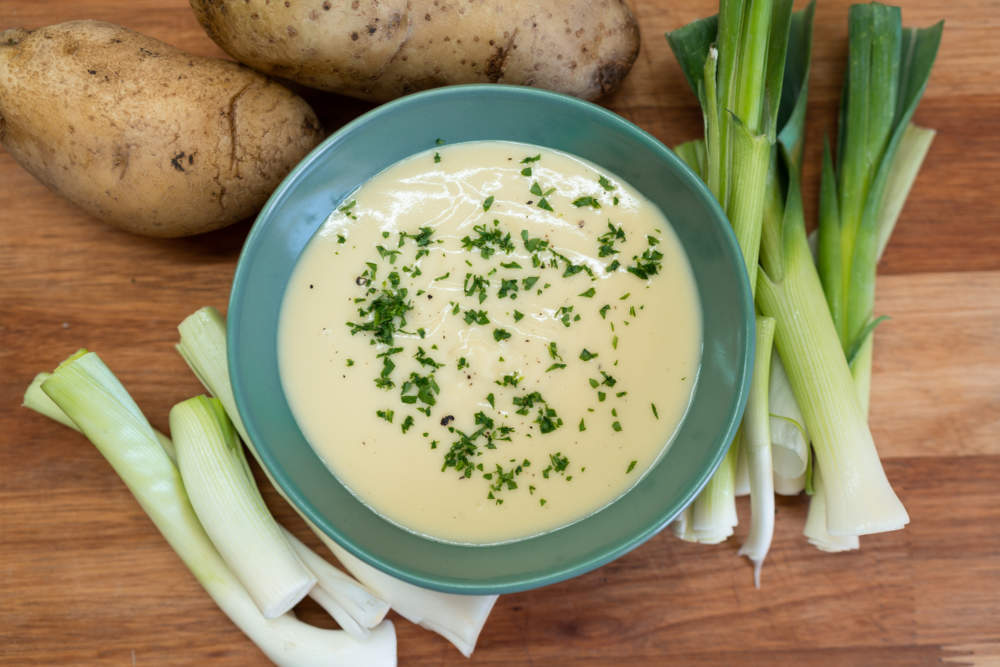 Top View Of Vichyssoise Soup, Potatoes And Leek On A Wooden Cutting Board.