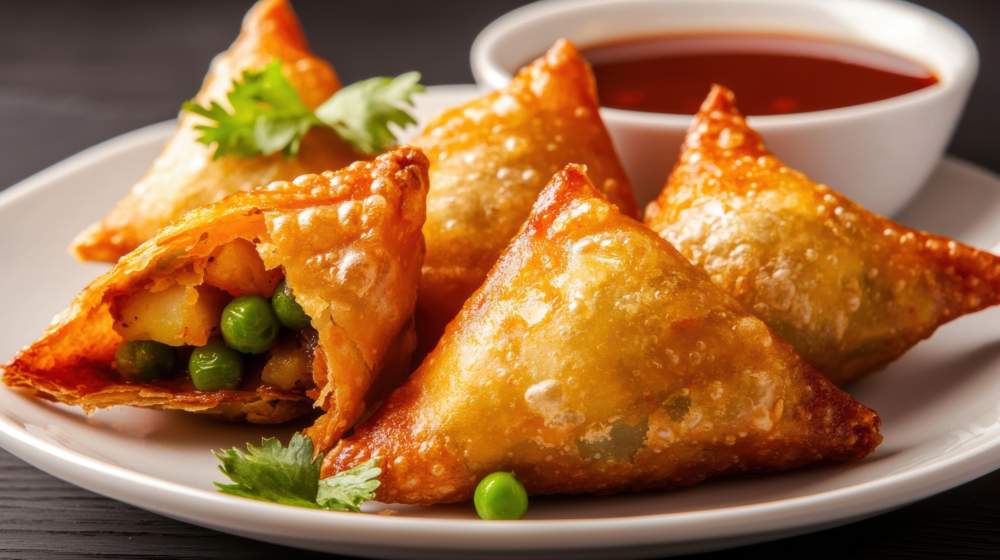 Crispy Golden Samosas Filled With Spiced Potatoes And Peas Served With Tangy Dipping Sauce
