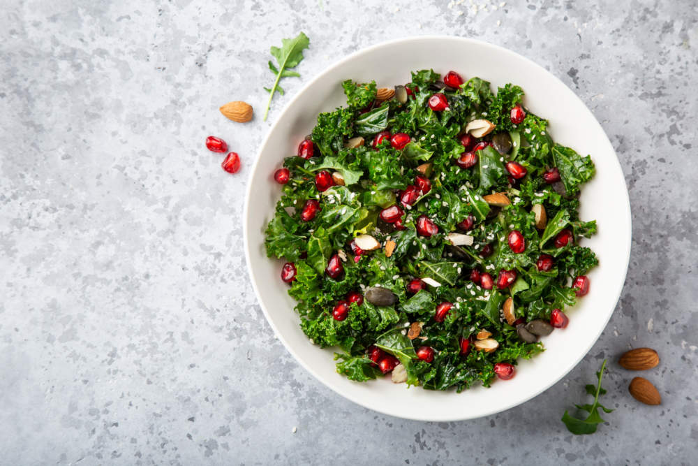 Fresh Kale, Roasted Chickpeas, Almond And Pomegranate Salad In White Bowl